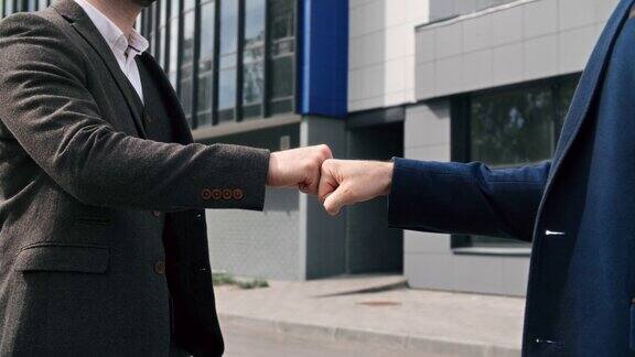 两个不认识的商人友好地握手问候非正式会议在市中心户外