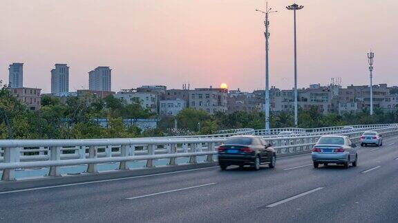 时光流逝桥上的汽车交通与日落背景
