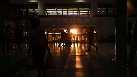 日落时分一些游客在机场候机楼里散步的剪影Covid-19大流行期间的旅行理念