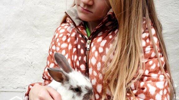 一个小女孩手里拿着一只兔子