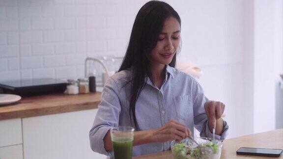 健康的亚洲妇女在家里的厨房里混合准备烹饪蔬菜沙拉素食主义者的素食概念