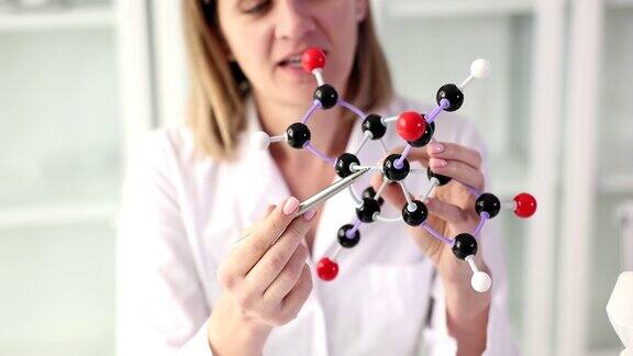 女科学家展示手中的分子结构模型与学生交流