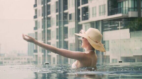年轻的亚洲女性享受在酒店的游泳池