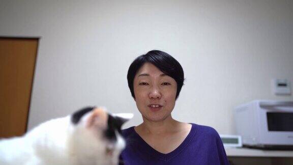 一个亚洲女人在和猫开视频电话会议