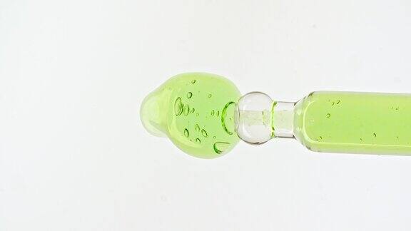 移液管与透明的绿色化妆品凝胶液血清与分子气泡油在白色背景天然有机化妆品、药品微距拍摄生产特写慢动作
