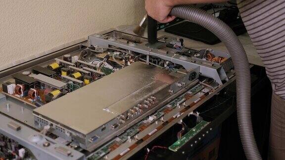 一个技术员在车间修理期间吸尘电视的特写