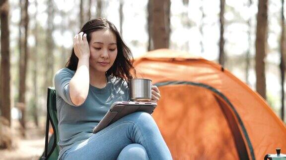 亚洲女人在露营时使用电子平板电脑