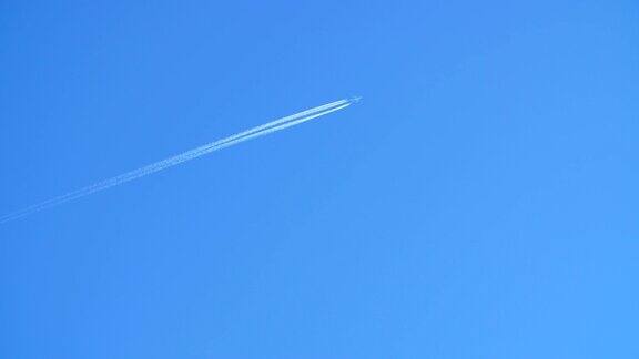 一架喷气式客机在高空飞行在清澈的蓝天上留下了尾迹