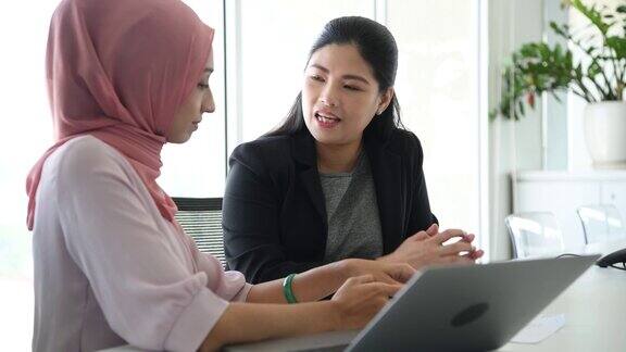 两个亚洲女商人在开会手提电脑