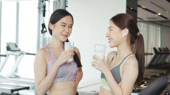 有吸引力的健身亚洲妇女完成锻炼和喝蛋白质牛奶奶昔维生素训练后健身健康的生活方式