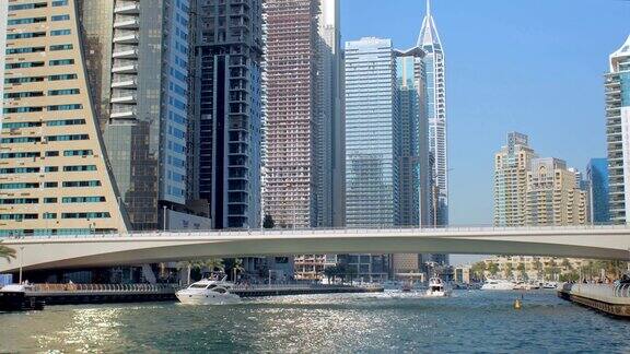 游艇和游船在阳光明媚的迪拜现代桥