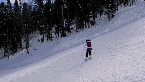 滑雪者在阳光明媚的冬日滑下山坡