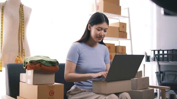 创业小企业主中小企业女企业家在收单箱上工作核对网上订单准备打包箱子卖给客户中小企业网上创业的想法