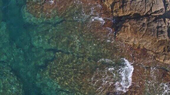 海浪走向岩石海岸的鸟瞰图