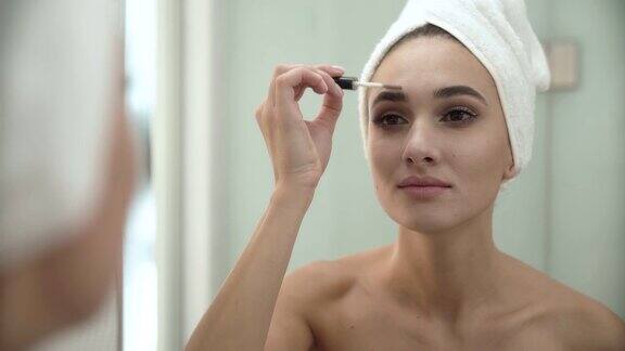 美容化妆一个女人在浴室镜子前刷眉毛
