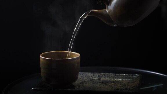 将热茶倒入玻璃茶壶和杯子中木制背景上有蒸汽健康热茶概念