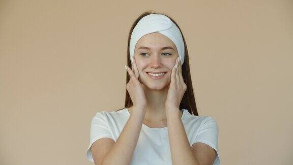 一位年轻貌美的女子用白色磨砂膏按摩面部美容和护理