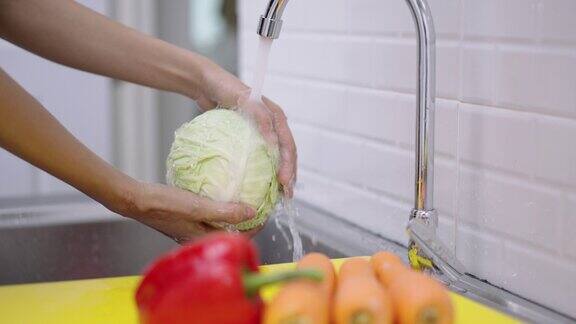 在家里厨房洗新鲜蔬菜的妇女