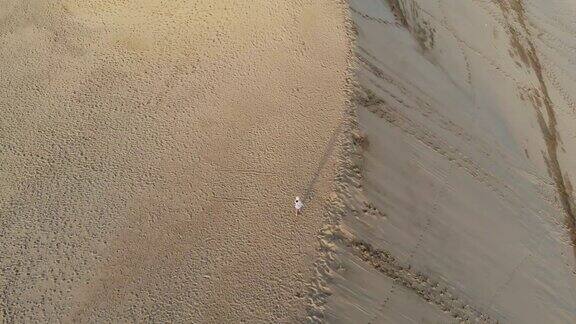 在日本的沙丘上行走的女人