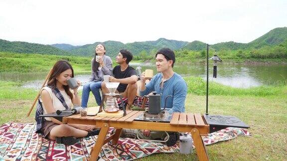 一群亚洲人在自然公园露营吃早餐喝咖啡