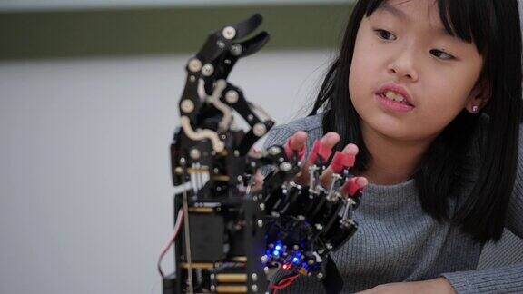 亚洲发明家孩子组装和测试机器人反应在实验室建筑师小孩子设计电路技术想法和协作开发机器人