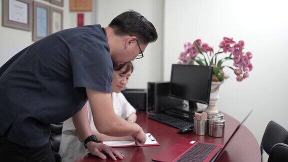 亚洲华人中年男性医生与他的医生同事讨论