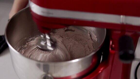 用搅拌器搅拌奶油用红色搅拌器煮奶油面团奶油的蛋糕