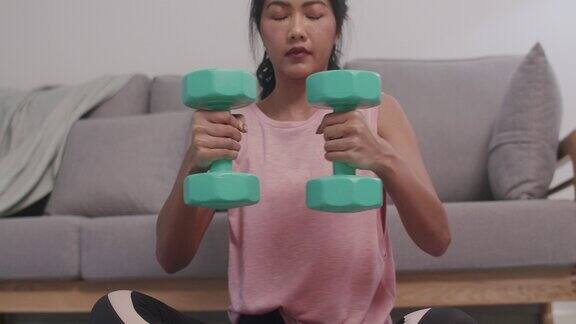 年轻的亚洲女性做运动在家健身健身教练穿着运动服进行锻炼以保持身材和健康