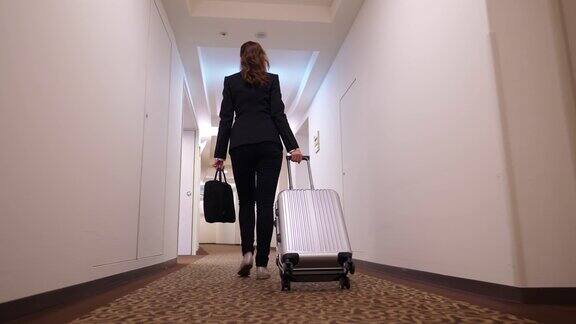 女人拿着手推车走在酒店走廊转到电梯大厅
