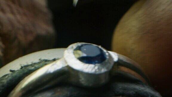 慢镜头微距的经验丰富的金匠工作在一个车间手工珠宝戒指与珍贵的宝石