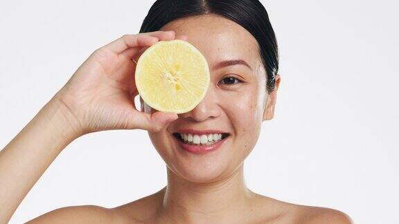 柠檬护肤面部和女性在工作室自然健康和白色背景快乐的亚洲模特美丽的肖像和柑橘类水果的面部化妆品发光维生素c或排毒皮肤病的结果