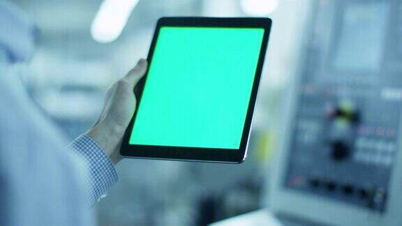 工人正在使用平板电脑与绿色屏幕纵向模式