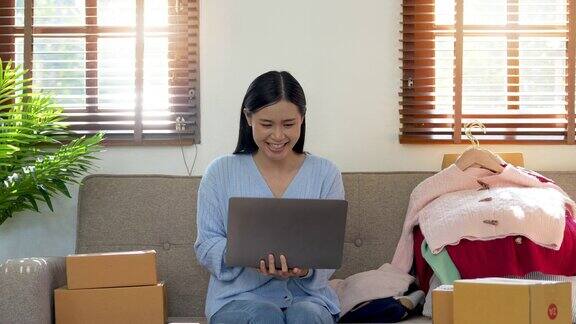 成功的女性工作和使用笔记本电脑在家里网上销售产品