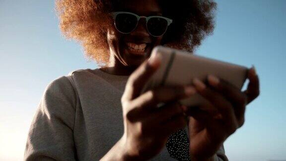非裔美国年轻潮人在沙滩上玩手机