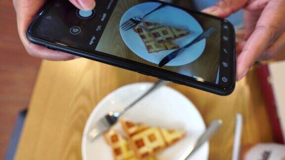 女博主用智能手机拍摄餐厅午餐