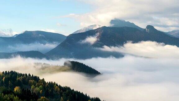 有雾的早晨与波的云在山区山谷景观时间流逝
