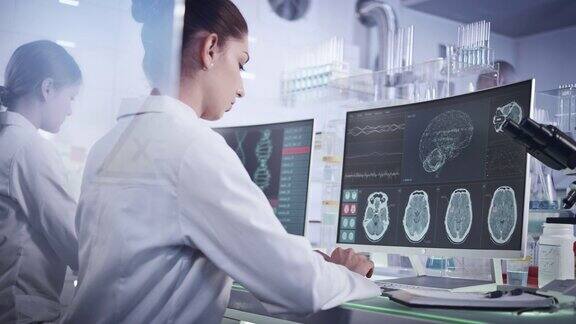 实验室女科学家电脑屏幕上的脑电波扫描研究