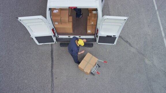 CS两个快递员从手推车上把包裹装进货车