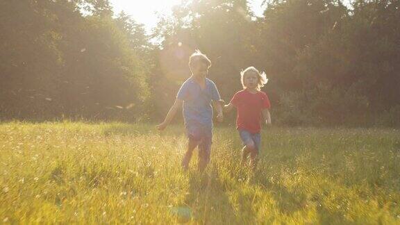 两个快乐的孩子在阳光下跑过田野