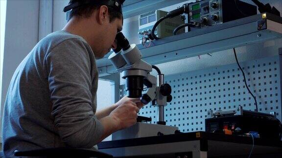 硬件修理实验室工程师用显微镜修理移动设备