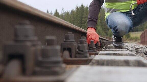 在铁路上工作工人拧紧铁路上的螺丝工程师在铁路上行走并检查轨道工作铁路轨道的检查和控制由工程师进行