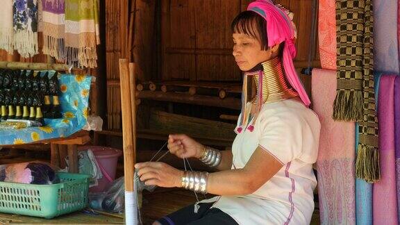 在泰国清莱附近的山村长脖子的妇女编织穿着传统服装