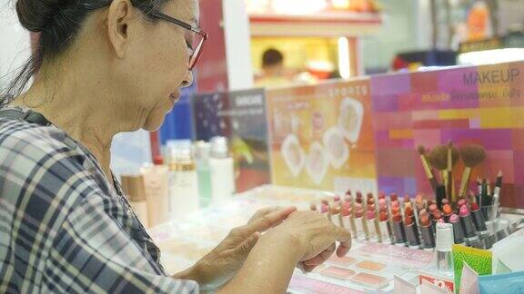 亚洲资深女性在商店试用口红