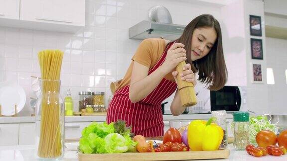 年轻的亚洲妇女在厨房做饭妻子正在为丈夫做一顿特别的饭