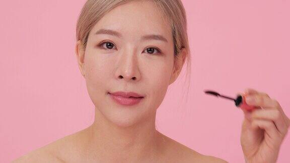 美丽的韩国女士用睫毛膏晚妆近距离
