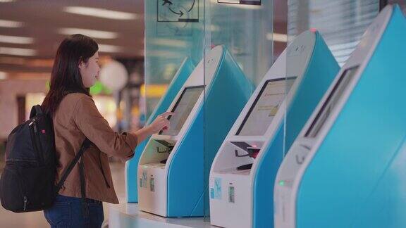 亚洲女性旅客在机场登机口使用扫描登机牌机该扫描登机牌机带有护照和触摸屏显示器