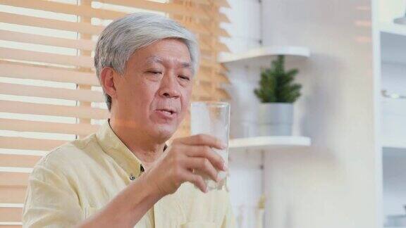 亚洲老年男子在家厨房喝牛奶退休生活方式积极的老年人健康
