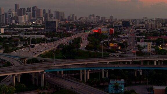日落时分从美国佛罗里达州北迈阿密的高架十字路口以及繁忙的95号州际公路眺望迈阿密市中心无人机制作的b-roll镜头与电影宽摇摄轨道摄像机运动