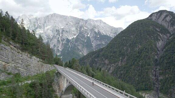 空中自行车手在山上一座漂亮的桥上骑着他的公路自行车