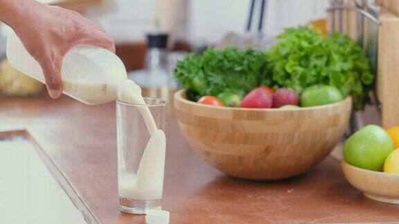 亚洲老人在家厨房用手倒牛奶退休生活方式积极的老年人健康